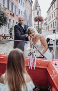 Ankunft der Braut am Standesamt, Vater hilft der Braut beim Aussteigen.