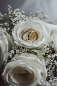 Eheringe in weißen Rosen im Brautstrauß.